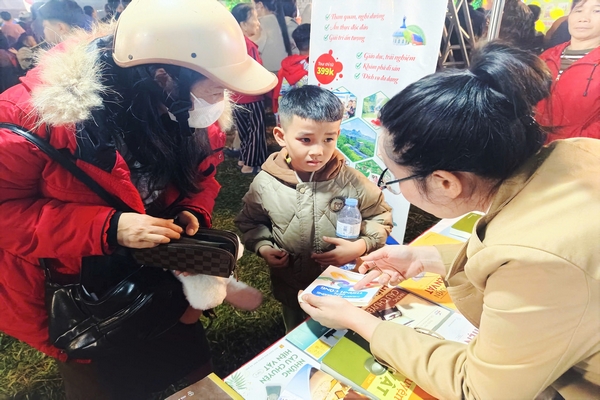 Một nhân viên MEDDOM Park đang tư vấn cho mẹ con một khách tham quan tại gian hàng trong Lễ hội Cam Cao Phong.